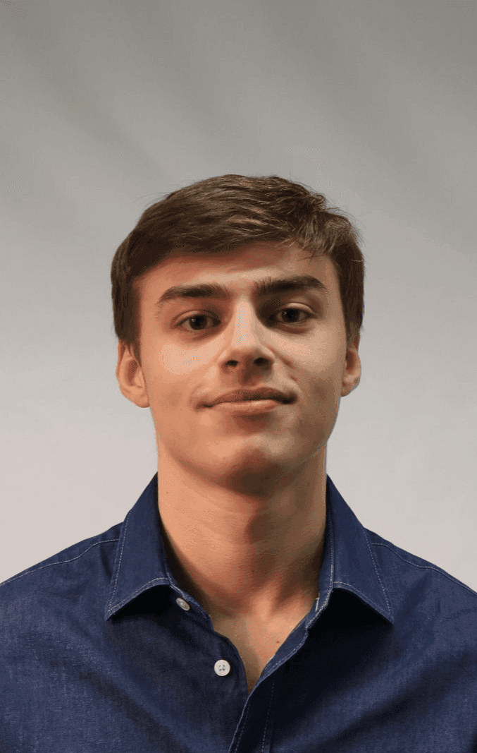 Person wearing a blue button-up shirt against a neutral background.